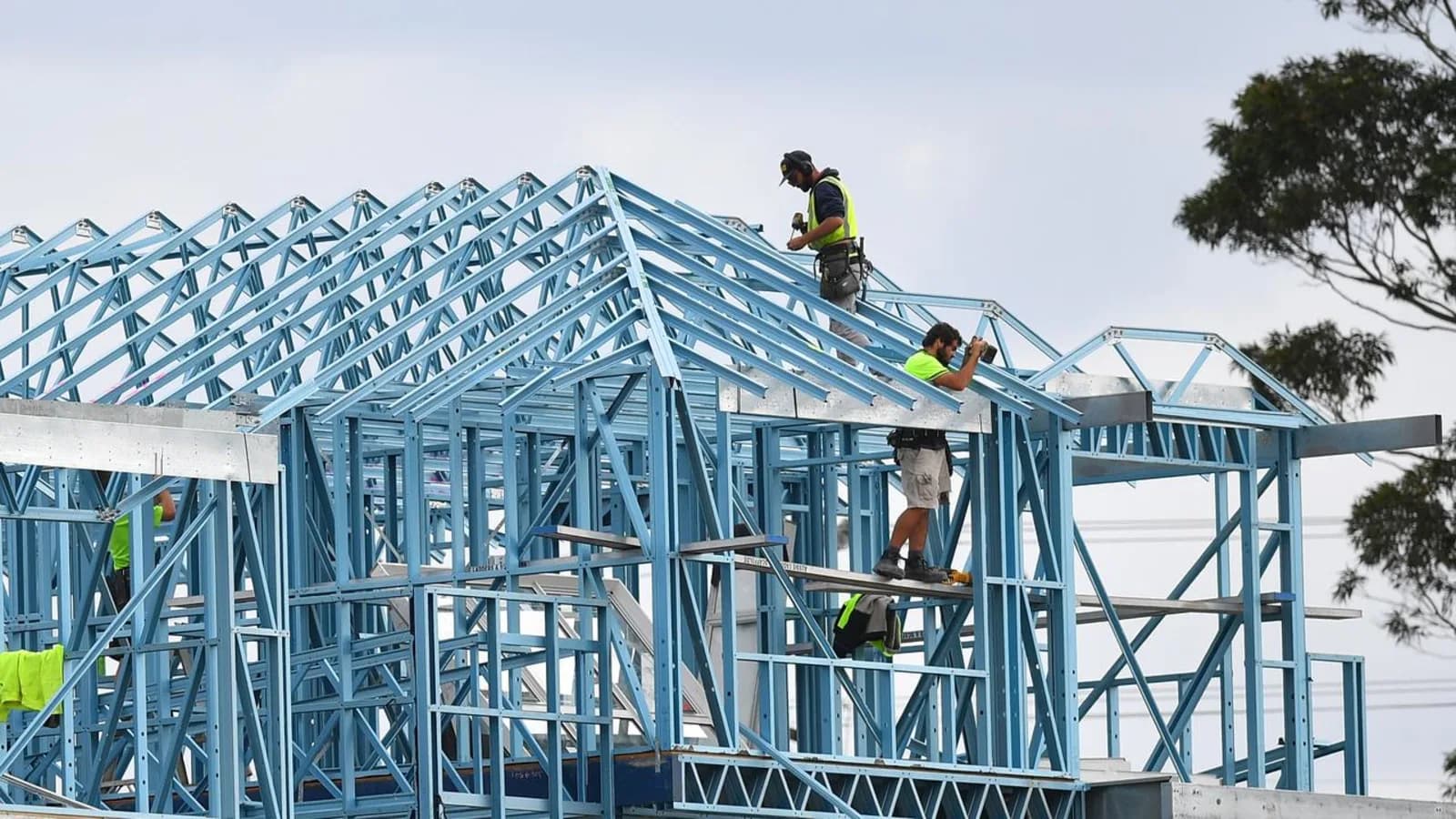 Builders assembling a steel frame on a residential construction site